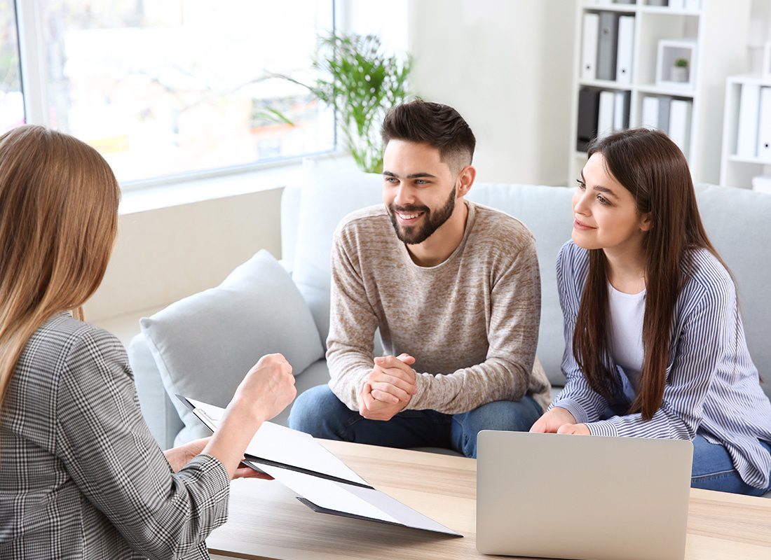 About Our Agency - Friendly Couple and Agent Sit Down Together To Review Documents